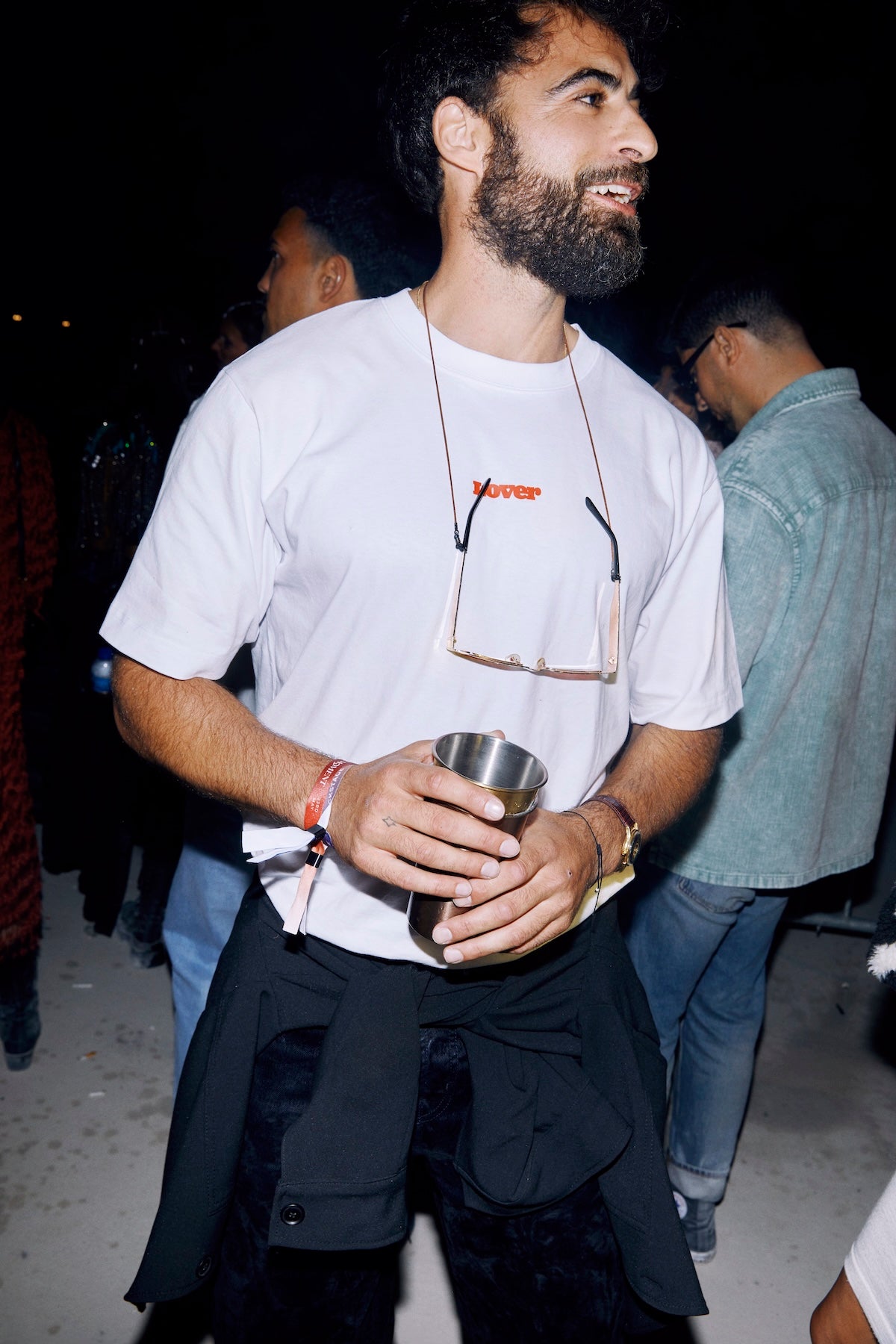 Person wearing LOVER T-shirt with red text logo in the crowd at a LOVER sparkling water event.